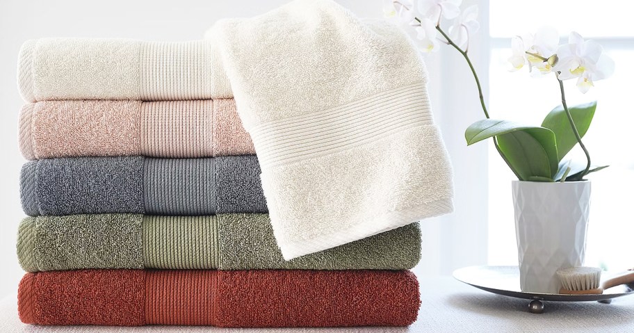 stack of folded bath towels near an orchid plant