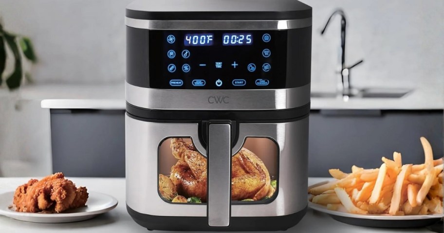 a silver programmable air fryer with a window with food cooking in it