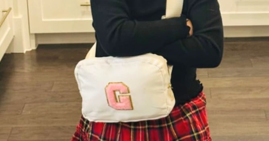little girl wearing an initial crossbody bag