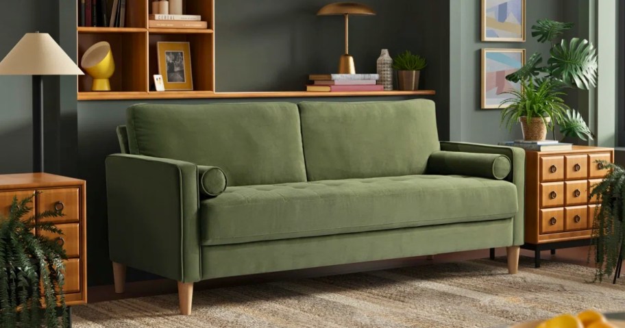 a green velvet sofa in a living room