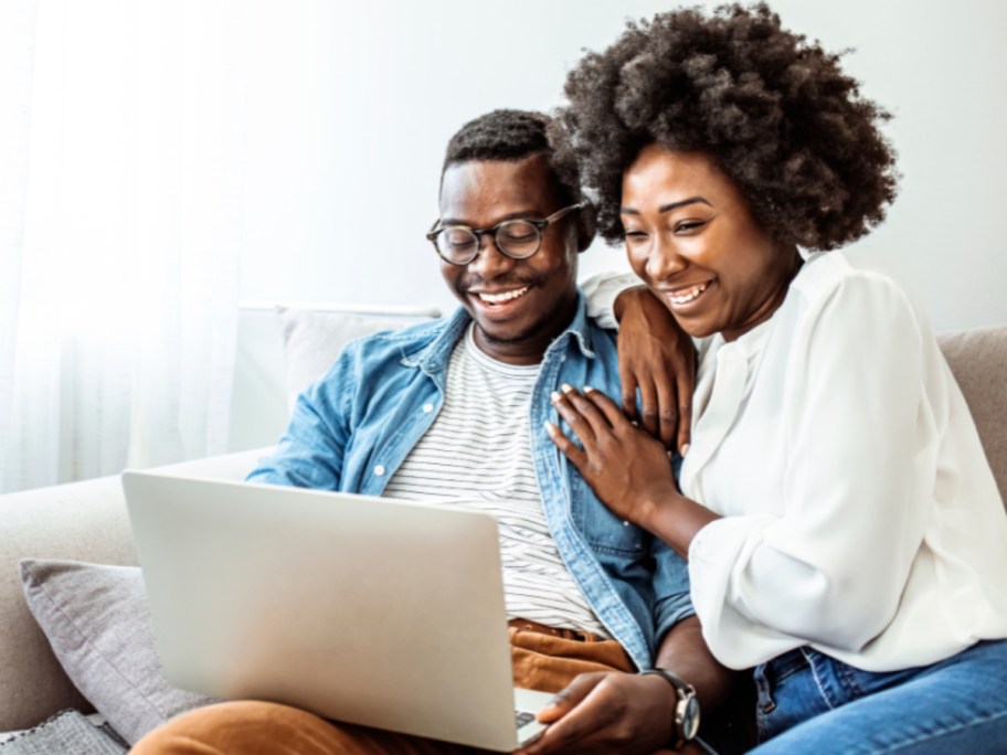 woman and man on a sofa looking at a laptop