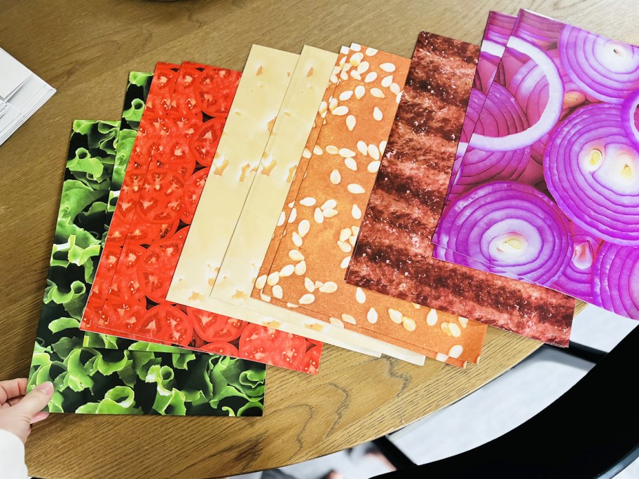 hand touching burger wrapping paper sheets on a table