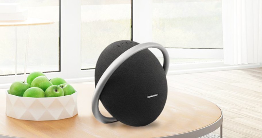 round black Bluetooth speaker on a coffee table