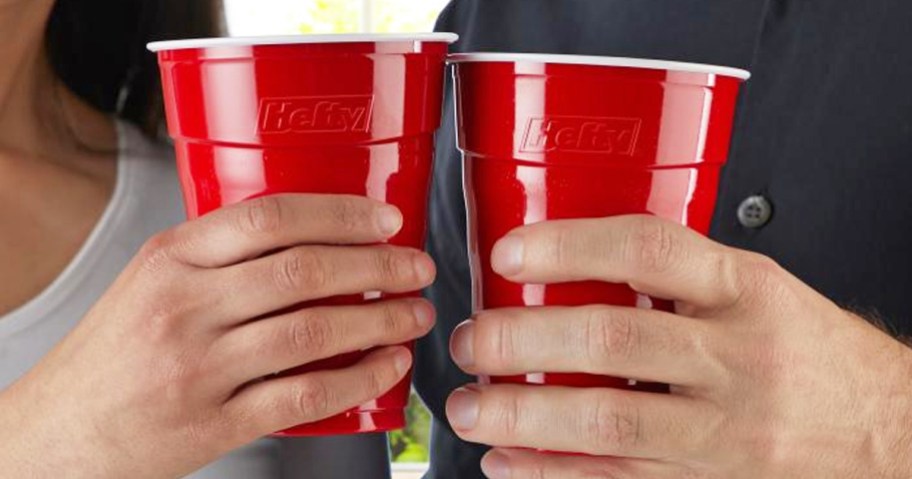 two people holding two red Hefty Disposable Plastic Cups