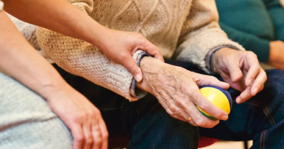 person holding hands with an older person holding a stress ball