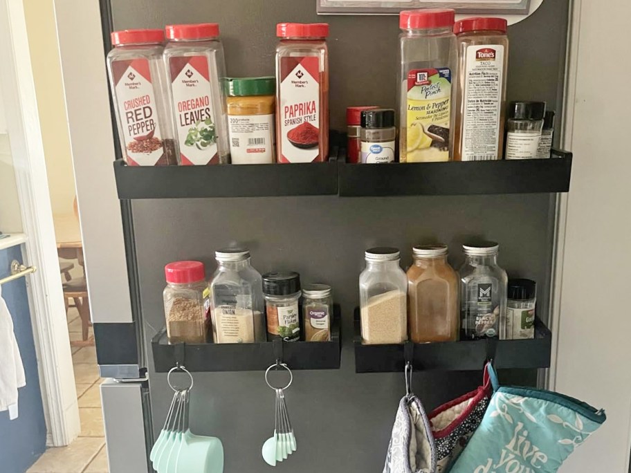 black shelves filled with spices on side of fridge