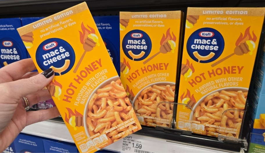 womans hand grabbing a box of Kraft hot honey mac and cheese from a store shelf
