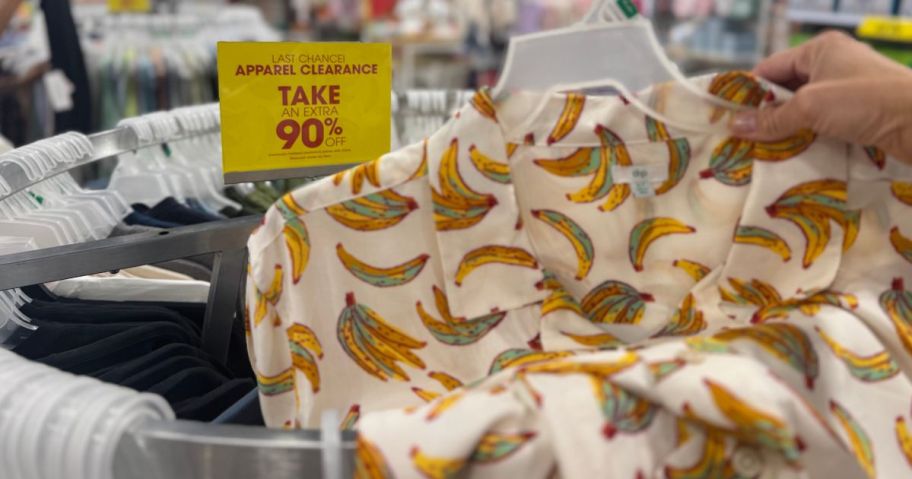 a yellow 90% off sign behind a button down shirt with bananas on it 