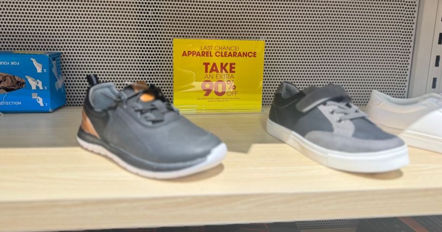 a yellow 90% off sign in front of sneakers 