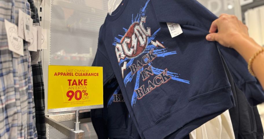 A person holding a blue ACDC t-shirt