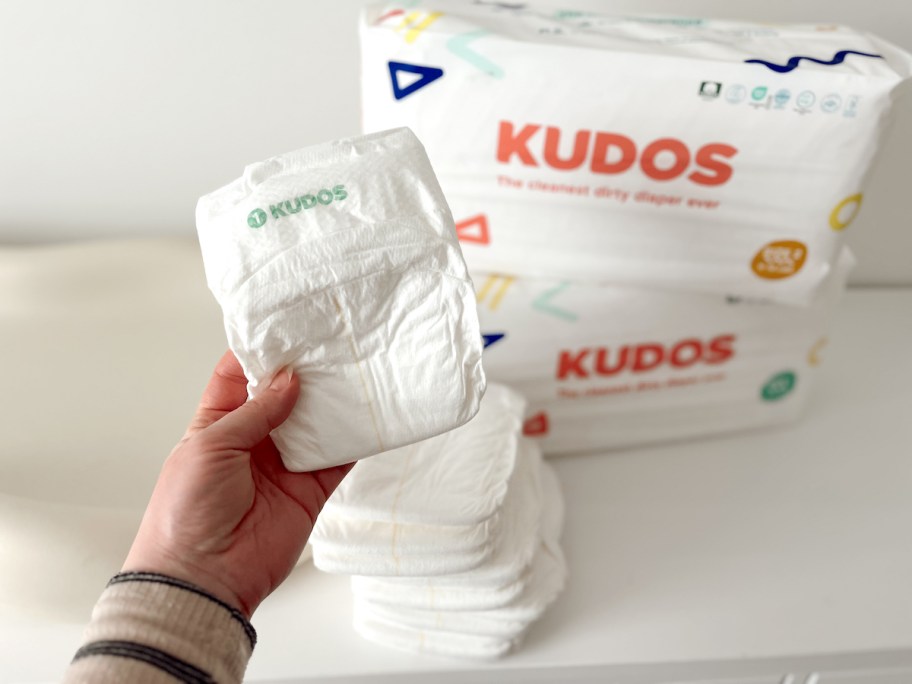 hand holding kudos baby diaper