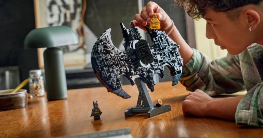 A person playing with a Batman LEGO set