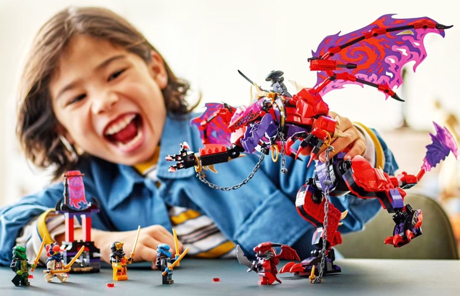 kid playing with LEGO NINJAGO Thunderfang Dragon of Chaos set