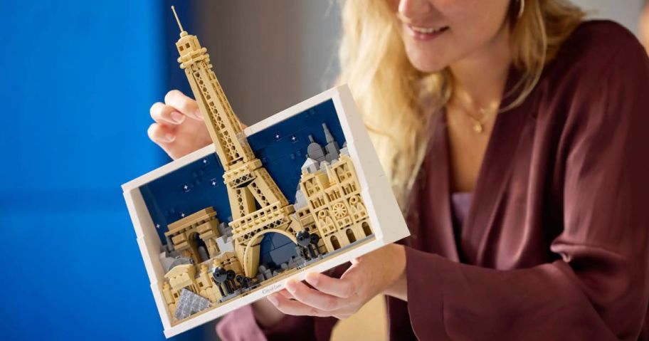 A person playing with a LEGO Paris set