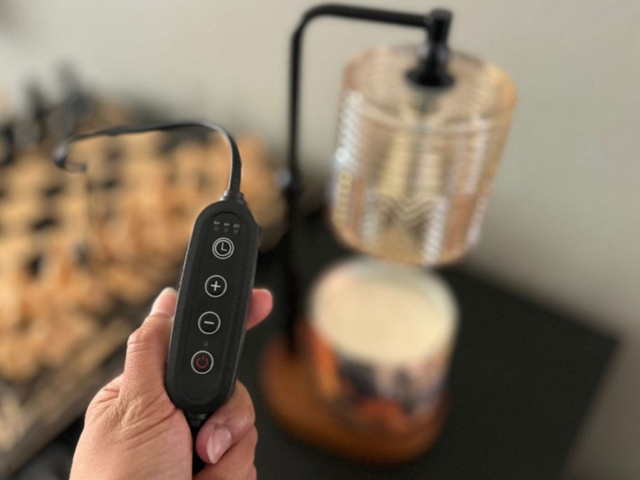 hand holding a lamp warmer remote in hand