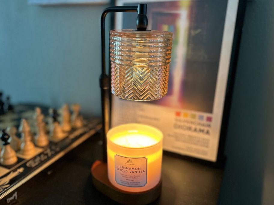 lamp wamer displayed on top of the table with picture in the background