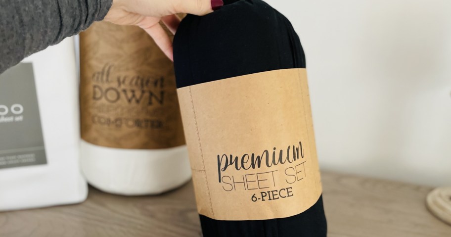 Person holding up black premium sheet set