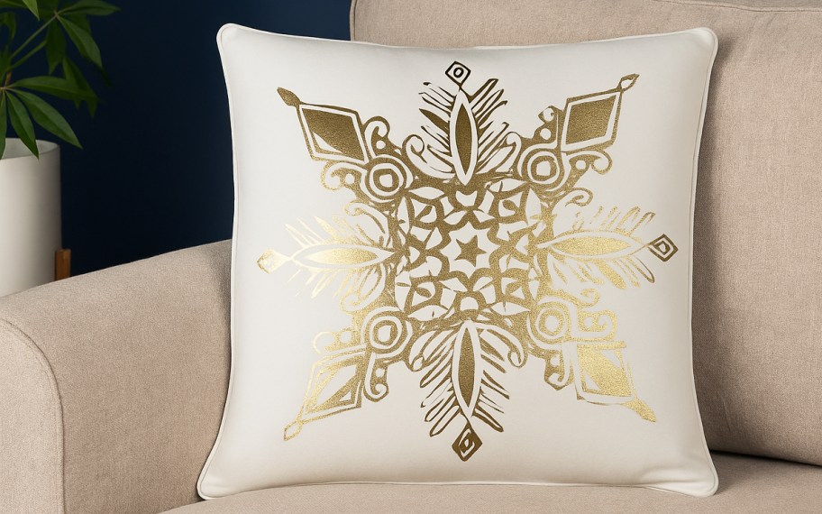 white and gold snowflake throw pillow on a couch