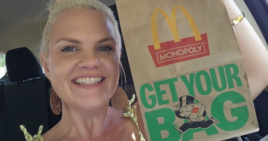 woman holding a mcdonald's monopoly bag in car