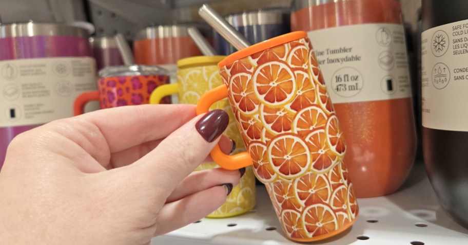 hand holding a mini orange print tumbler