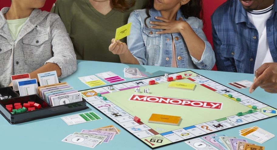 Family playing monopoly with it on the table