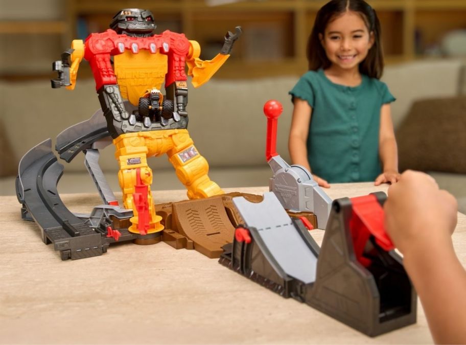 two kids playing with a monster jam playset