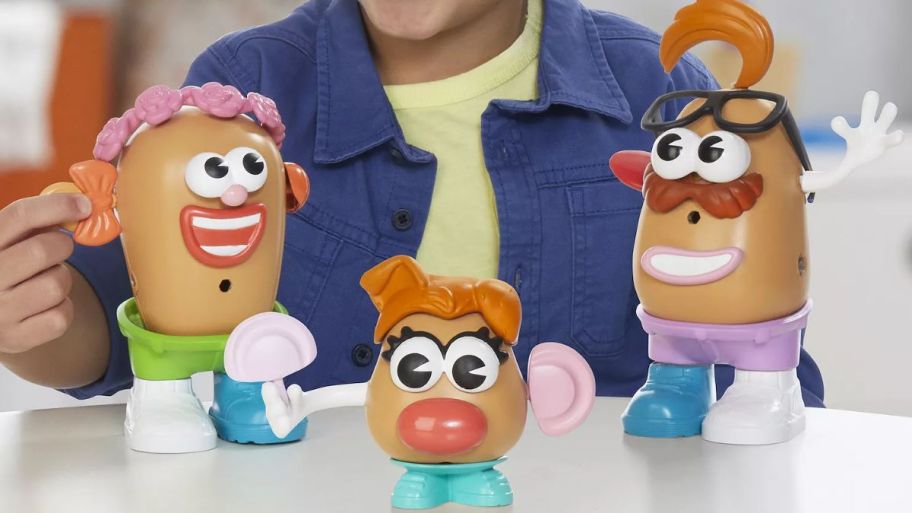 child playing with Mr Potato head Gift set on top of the table