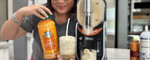 Woman holding a bottle of Starbucks Caramel Macchiato and a cup of frozen drink next to a Ninja Slushi Maker