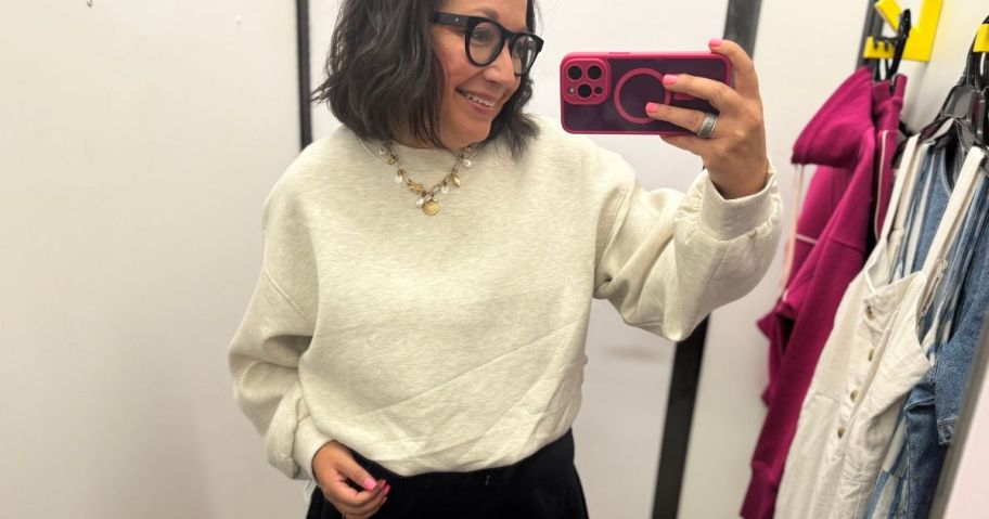 Woman wearing an old navy sweatshirt inside a dressing room
