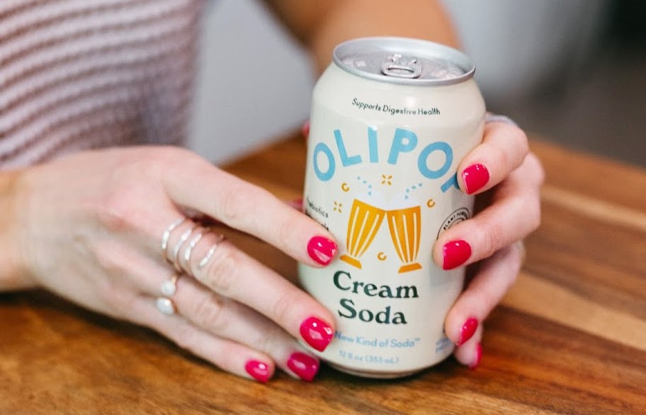 hands holding an Olipop Cream Soda can