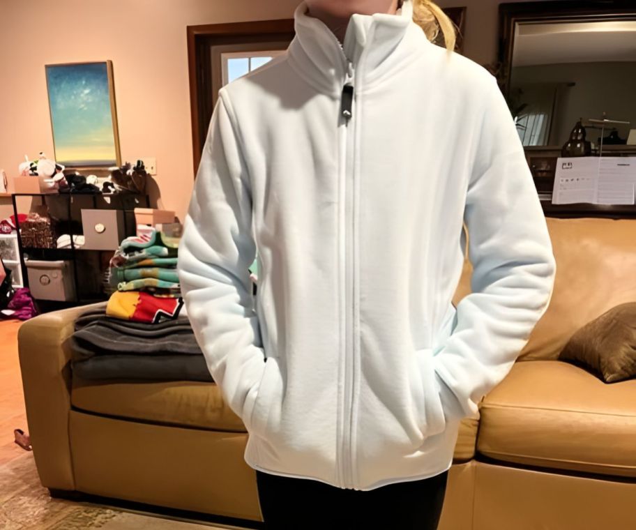 A child wearing a white zip-up fleece jacket