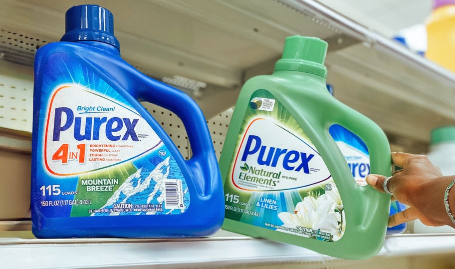 hand grabbing large bottles of Purex Liquid Laundry Detergents from store shelf