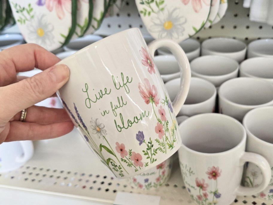 hand holding up a floral print coffee mug