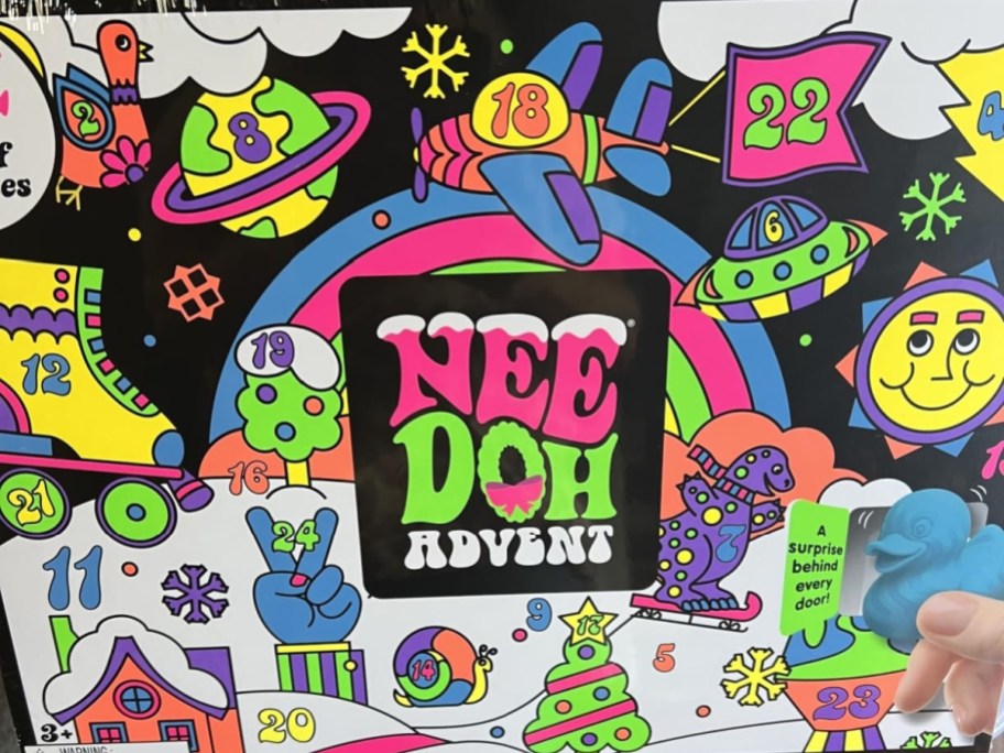A colorful Schylling NeeDoh Squishmas advent calendar box featuring playful cartoon illustrations, numbered doors, and a central logo.