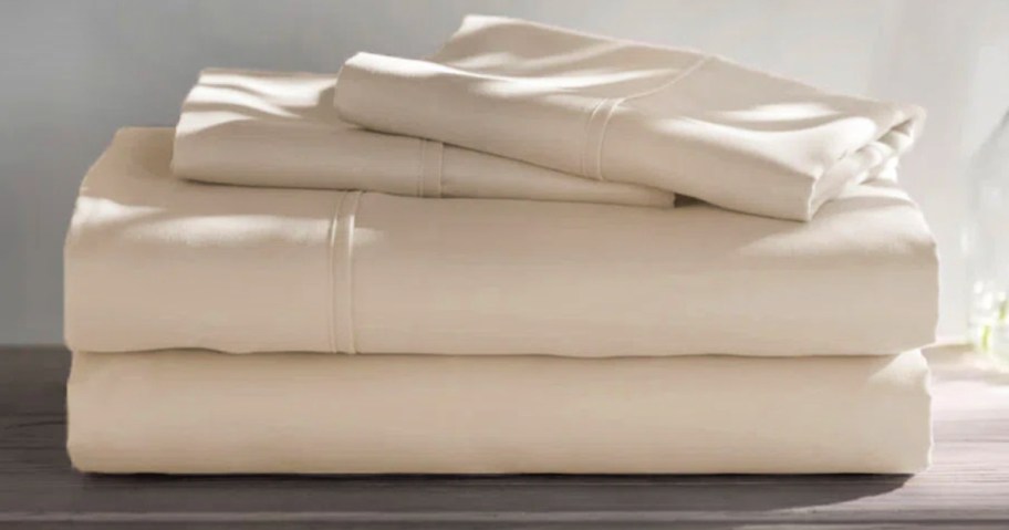 Sheet set with pillowcases folded on top of wooden countertop