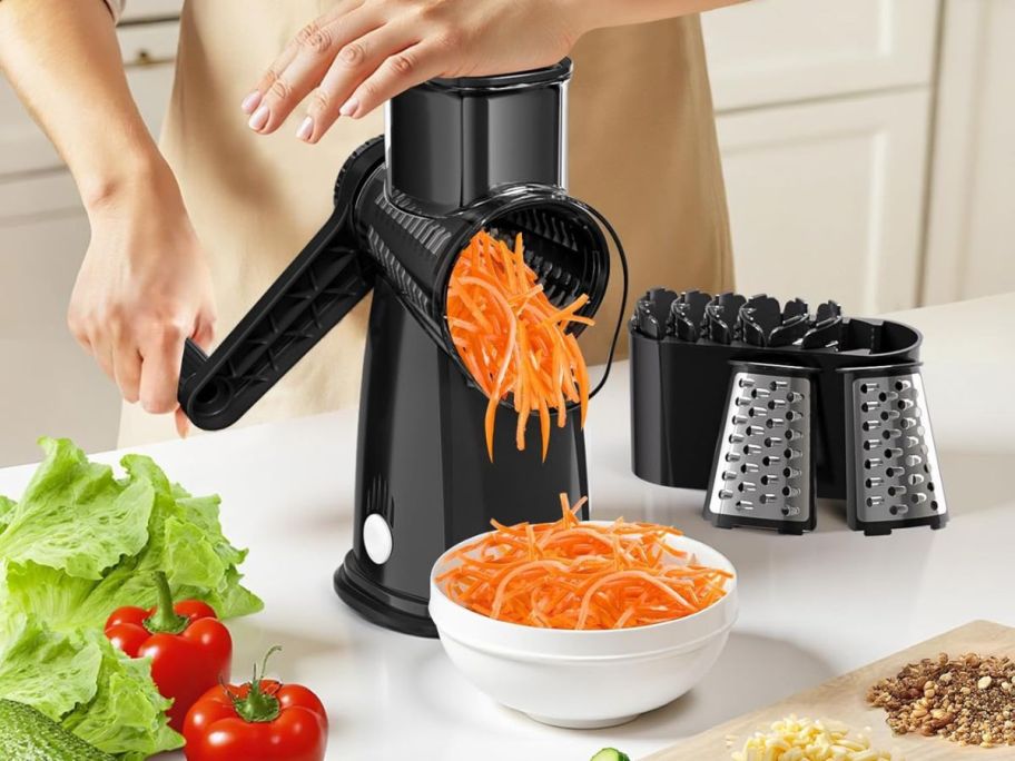 A person using a rotary shredder for carrots
