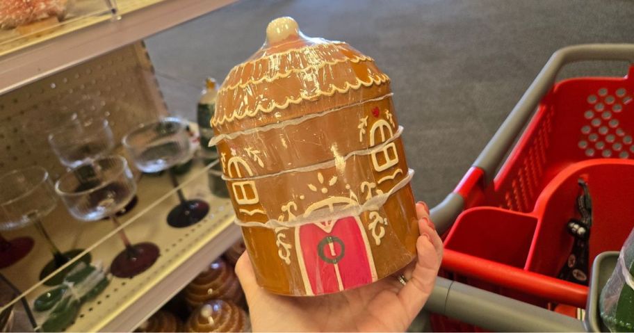 A person holding a brown, ceramic gingerbread cookie jar
