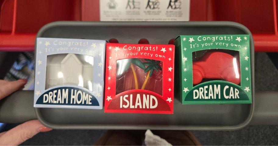 3 boxes of small gifts: tiny home, island, and car in a cart