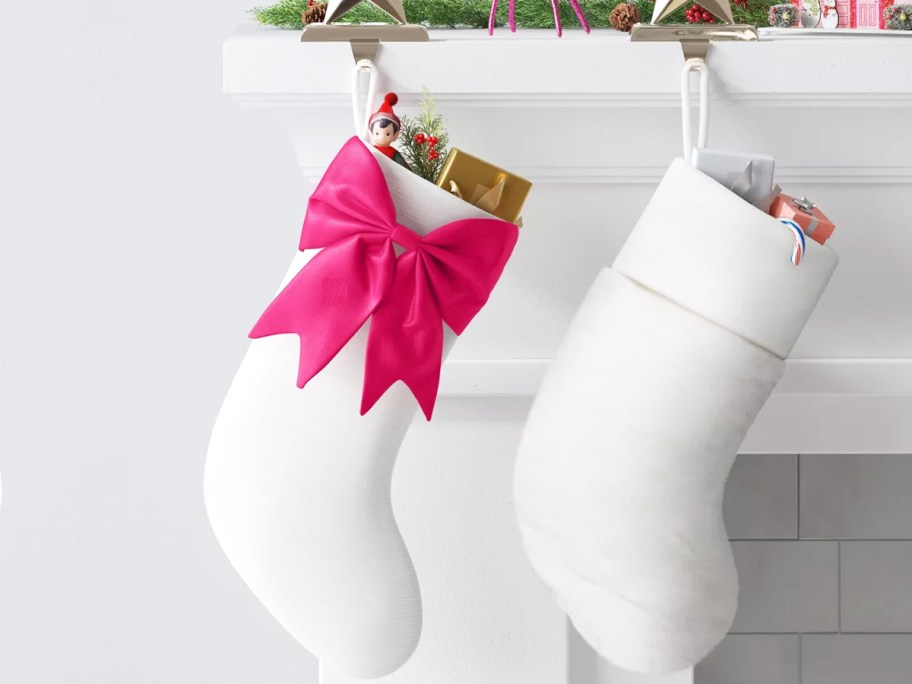 two white stockings hanging from a mantel