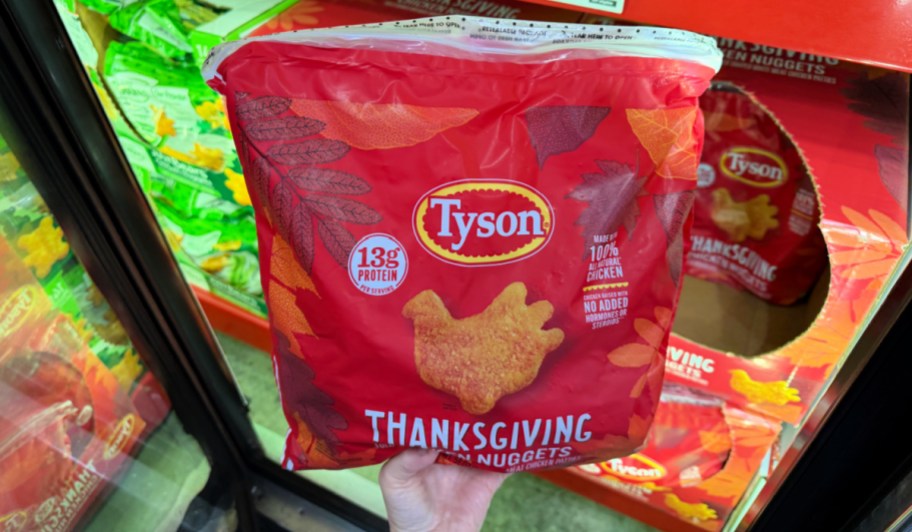 hand holding up bag of tyson thanksgiving nuggets inside sams club