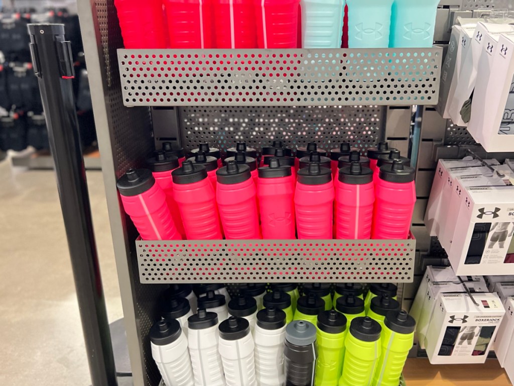 Under Armour water bottles in different colors on display in sporting goods store