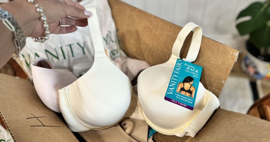 grabbing a Vanity Fair bra from a shipping box
