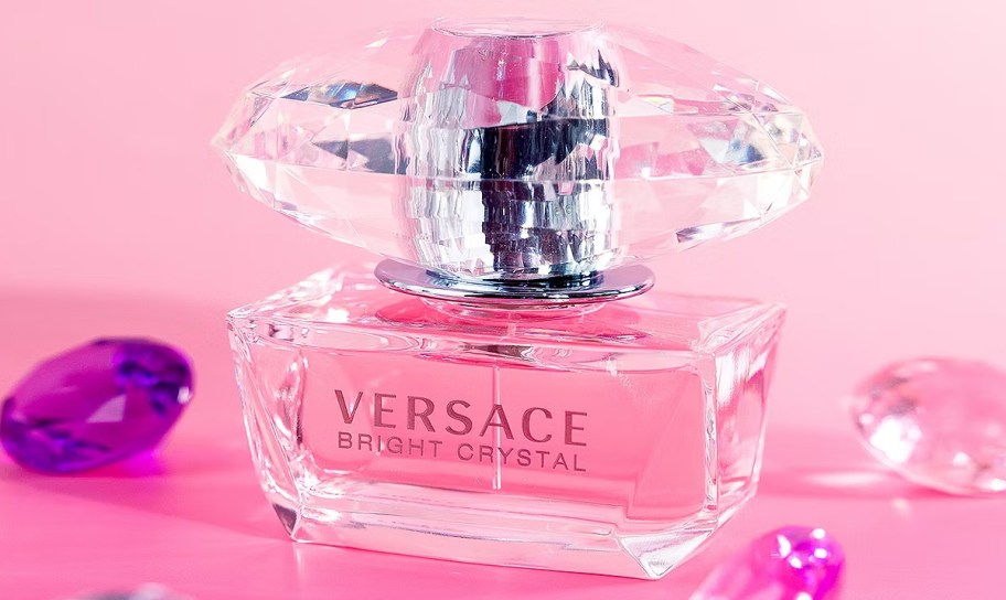 pink bottle of Versace Bright Crystal near gemstones