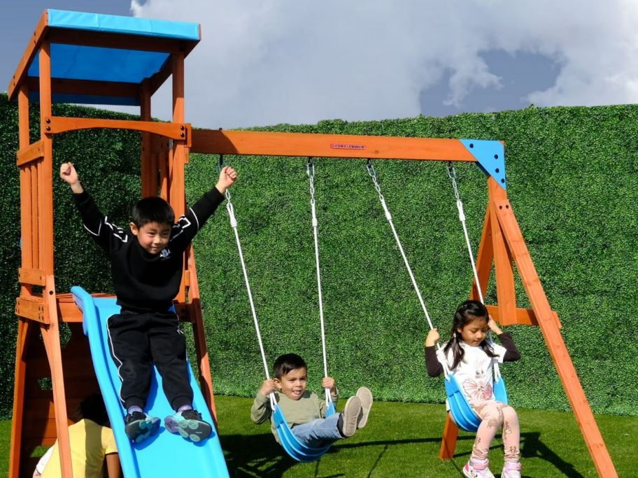 Wooden set with swing and slide with kids on it