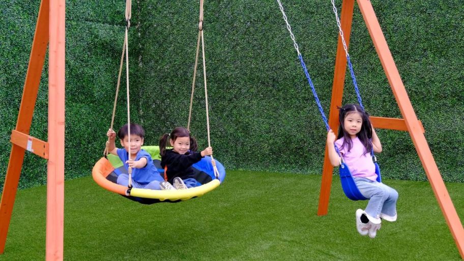 Wooden swing set with kid son it
