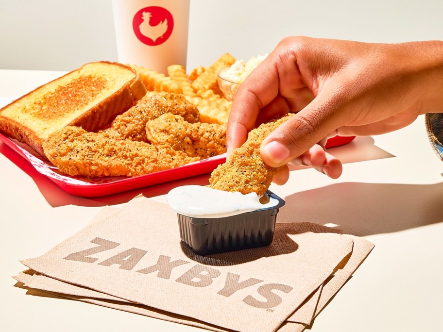 hand dipping chicken finger into ranch