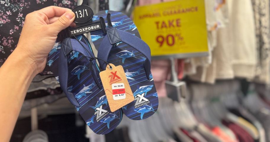 a person holding a pair of flip flops in a store