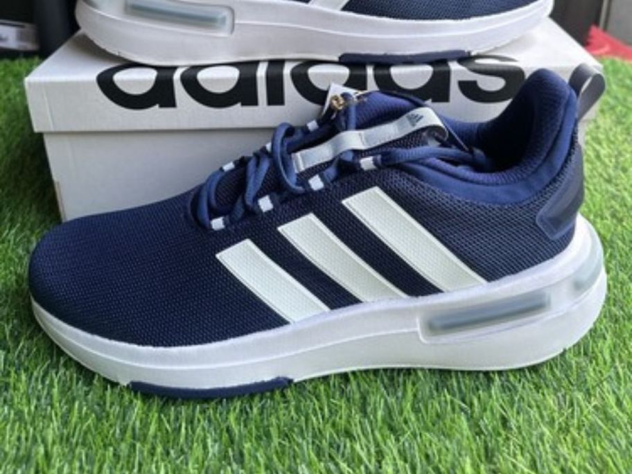 adidas shoes next to box on grass