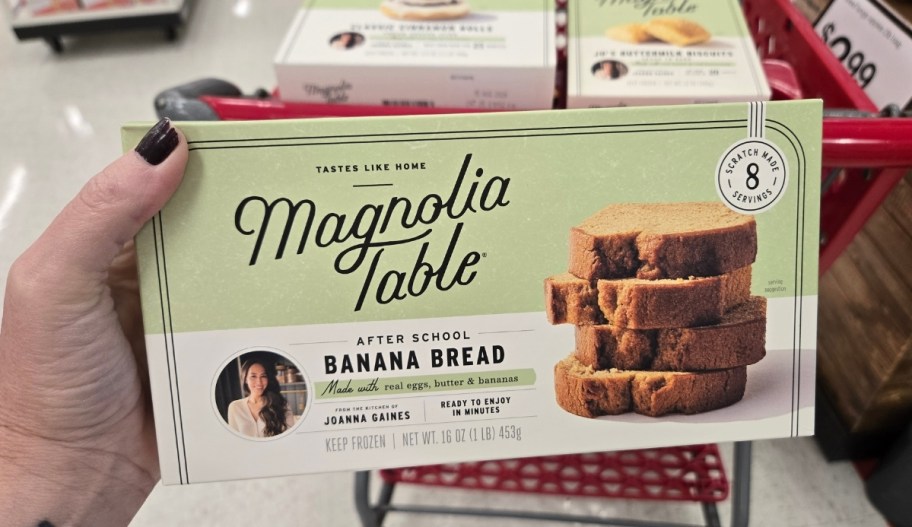 womans hand holding a box of banana bread