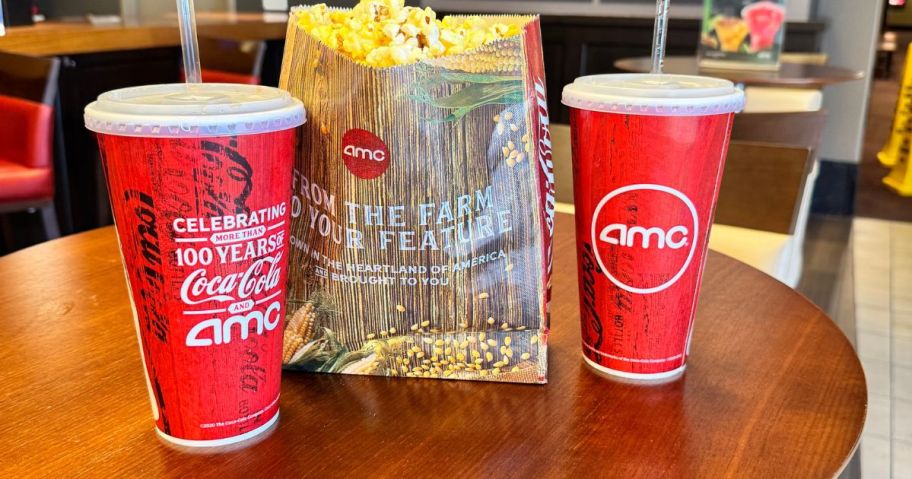 two amc drinks and popcorn on table in theatre